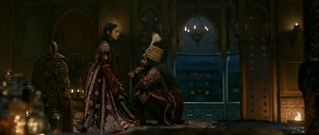 Movie still from “Padmaavat” (2018), directed by Sanjay Leela Bhansali – A man kneeling down next to a woman in medieval clothing; Wide shot, Over the shoulder angle