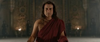 Movie still from “Padmaavat” (2018), directed by Sanjay Leela Bhansali – A man with long black hair wearing a red robe; Close Up shot, Low angle