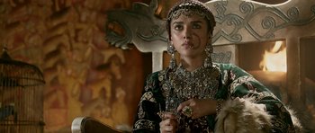 Movie still from “Padmaavat” (2018), directed by Sanjay Leela Bhansali – A woman in a green and black dress holding a cigarette; Close Up shot, Over the shoulder angle