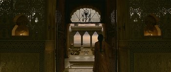 Movie still from “Padmaavat” (2018), directed by Sanjay Leela Bhansali – A woman standing in an archway looking out at a building; Extreme Wide shot, Low angle