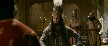 Movie still from “Padmaavat” (2018), directed by Sanjay Leela Bhansali – A man with a long beard wearing a hat; Close Up shot, Over the shoulder angle