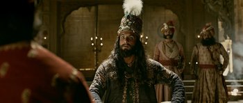 Movie still from “Padmaavat” (2018), directed by Sanjay Leela Bhansali – A man with a long beard wearing a hat; Close Up shot, Over the shoulder angle