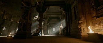 Movie still from “Padmaavat” (2018), directed by Sanjay Leela Bhansali – A man sitting on the ground in front of a statue; Extreme Wide shot, Low angle