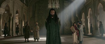 Movie still from “Padmaavat” (2018), directed by Sanjay Leela Bhansali – A man with long black hair standing in a room; Wide shot, Low angle