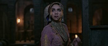 Movie still from “Padmaavat” (2018), directed by Sanjay Leela Bhansali – A woman in a purple and gold dress with a cigarette in her mouth; Close Up shot, Over the shoulder angle