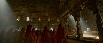 Movie still from “Padmaavat” (2018), directed by Sanjay Leela Bhansali – A group of people dressed in red and standing in front of a building; Extreme Wide shot, Low angle