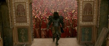 Movie still from “Padmaavat” (2018), directed by Sanjay Leela Bhansali – A man in armor walking down a path towards a group of people; Wide shot, High angle