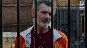 Movie still from “Pain and Glory” (2019), directed by Pedro Almodóvar – A man with a gray beard wearing an orange and white jacket; Close Up shot, Over the shoulder angle