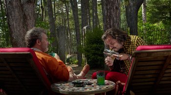 Movie still from “Pain and Glory” (2019), directed by Pedro Almodóvar – Two men sitting at a table in the woods looking at their cell phones; Wide shot, Overhead angle