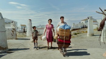 Movie still from “Pain and Glory” (2019), directed by Pedro Almodóvar – A man , woman , and boy standing next to a bicycle; Wide shot, Low angle