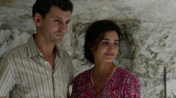Movie still from “Pain and Glory” (2019), directed by Pedro Almodóvar – A man and a woman standing next to each other in front of a stone wall; Close Up shot, Low angle