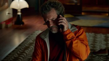 Movie still from “Pain and Glory” (2019), directed by Pedro Almodóvar – A man in an orange jacket talking on a cell phone; Close Up shot, High angle