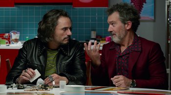 Movie still from “Pain and Glory” (2019), directed by Pedro Almodóvar – Two men sitting at a table talking to each other; Medium shot, Over the shoulder angle
