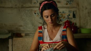 Movie still from “Pain and Glory” (2019), directed by Pedro Almodóvar – A woman in a dress and a headband is sewing; Close Up shot, High angle