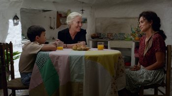Movie still from “Pain and Glory” (2019), directed by Pedro Almodóvar – A woman sitting at a table with a child; Medium shot, Over the shoulder angle