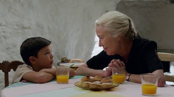 Movie still from “Pain and Glory” (2019), directed by Pedro Almodóvar – An older woman and a young girl sitting at a table with food; Close Up shot, Over the shoulder angle