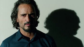 Movie still from “Pain and Glory” (2019), directed by Pedro Almodóvar – A person wearing a black shirt; Close Up shot, Low angle