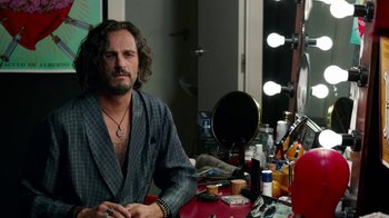 Movie still from “Pain and Glory” (2019), directed by Pedro Almodóvar – A man sitting in front of a mirror in a dressing room; Medium shot, Over the shoulder angle