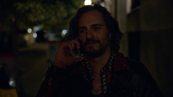Movie still from “Pain and Glory” (2019), directed by Pedro Almodóvar – A man talking on a cell phone while standing outside at night; Close Up shot, Over the shoulder angle
