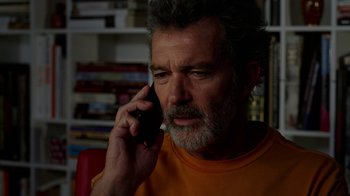 Movie still from “Pain and Glory” (2019), directed by Pedro Almodóvar – An older man talking on a cell phone while sitting down; Close Up shot, Low angle