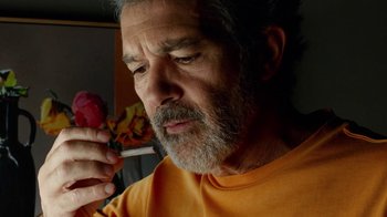 Movie still from “Pain and Glory” (2019), directed by Pedro Almodóvar – An older man holding a cigarette and looking at a piece of paper; Extreme Close Up shot, Low angle