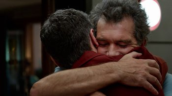 Movie still from “Pain and Glory” (2019), directed by Pedro Almodóvar – A couple of men hugging each other in a room; Close Up shot, Over the shoulder angle