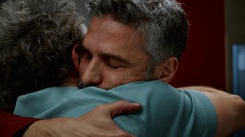 Movie still from “Pain and Glory” (2019), directed by Pedro Almodóvar – A man is hugging another man in a blue shirt; Close Up shot, Over the shoulder angle