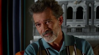 Movie still from “Pain and Glory” (2019), directed by Pedro Almodóvar – An older man with grey hair is looking at the camera; Close Up shot, Over the shoulder angle