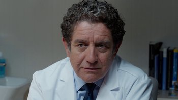 Movie still from “Pain and Glory” (2019), directed by Pedro Almodóvar – A person wearing a lab coat; Close Up shot, Low angle