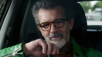 Movie still from “Pain and Glory” (2019), directed by Pedro Almodóvar – An older man wearing glasses sitting in a car; Close Up shot, Over the shoulder angle