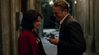 Movie still from “Papillon” (2017), directed by Michael Noer – A man and a woman looking at a cell phone; Medium shot, Over the shoulder angle