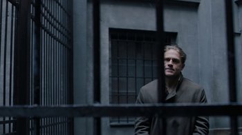 Movie still from “Papillon” (2017), directed by Michael Noer – A man standing in front of a jail cell; Medium shot, Over the shoulder angle