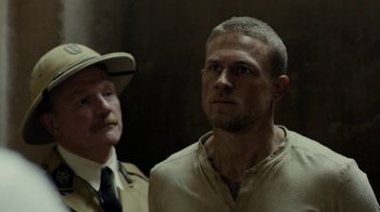 Movie still from “Papillon” (2017), directed by Michael Noer – A man standing next to another man; Close Up shot, Over the shoulder angle