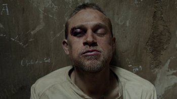Movie still from “Papillon” (2017), directed by Michael Noer – A person with a bruised eye; Close Up shot, Overhead angle