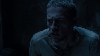 Movie still from “Papillon” (2017), directed by Michael Noer – A person in a dark room; Close Up shot, High angle