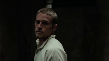 Movie still from “Papillon” (2017), directed by Michael Noer – A person wearing a white shirt; Close Up shot, Over the shoulder angle