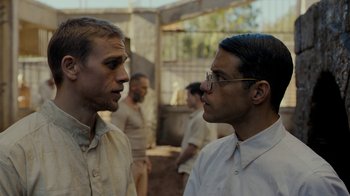 Movie still from “Papillon” (2017), directed by Michael Noer – Two men are standing in front of each other; Close Up shot, Over the shoulder angle
