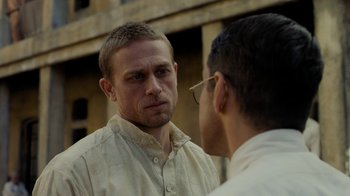 Movie still from “Papillon” (2017), directed by Michael Noer – A man in a white shirt and a man in a white shirt; Close Up shot, Over the shoulder angle