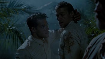 Movie still from “Papillon” (2017), directed by Michael Noer – Two men are standing in the rain and one has his hand on the other's shoulder; Close Up shot, Low angle