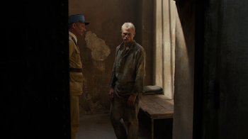 Movie still from “Papillon” (2017), directed by Michael Noer – Two men standing next to each other in a room; Wide shot, Over the shoulder angle