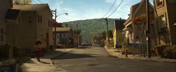 Movie still from “ParaNorman” (2012), directed by Sam Fell – An image of a street scene with a car going down the road; Extreme Wide shot, High angle