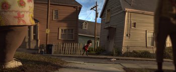 Movie still from “ParaNorman” (2012), directed by Sam Fell – A person walking down a street near some houses; Extreme Wide shot, High angle
