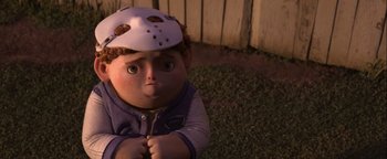Movie still from “ParaNorman” (2012), directed by Sam Fell – A child with a hockey mask on is sitting in the grass; Close Up shot, High angle