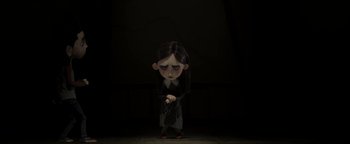 Movie still from “ParaNorman” (2012), directed by Sam Fell – A cartoon of a girl in a dark room holding a gun; Medium shot, Low angle