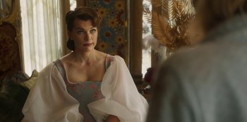 Movie still from “Paradise Hills” (2019), directed by Alice Waddington – A woman in a dress looking into a mirror; Medium shot, Over the shoulder angle