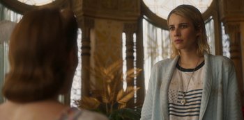 Movie still from “Paradise Hills” (2019), directed by Alice Waddington – A woman standing in front of another woman in front of a building; Close Up shot, Over the shoulder angle