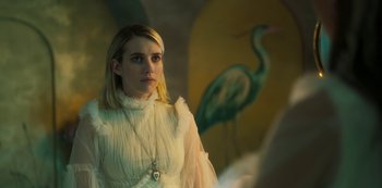 Movie still from “Paradise Hills” (2019), directed by Alice Waddington – A woman in a white dress standing in front of a painting; Close Up shot, Over the shoulder angle