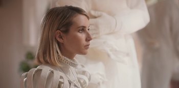 Movie still from “Paradise Hills” (2019), directed by Alice Waddington – A woman in a white dress looking to the side; Close Up shot, Low angle