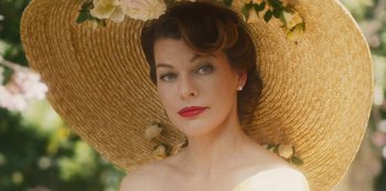 Movie still from “Paradise Hills” (2019), directed by Alice Waddington – A woman wearing a straw hat with flowers in the background; Close Up shot, Low angle