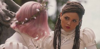 Movie still from “Paradise Hills” (2019), directed by Alice Waddington – A woman with pink hair is looking at another woman; Close Up shot, Over the shoulder angle